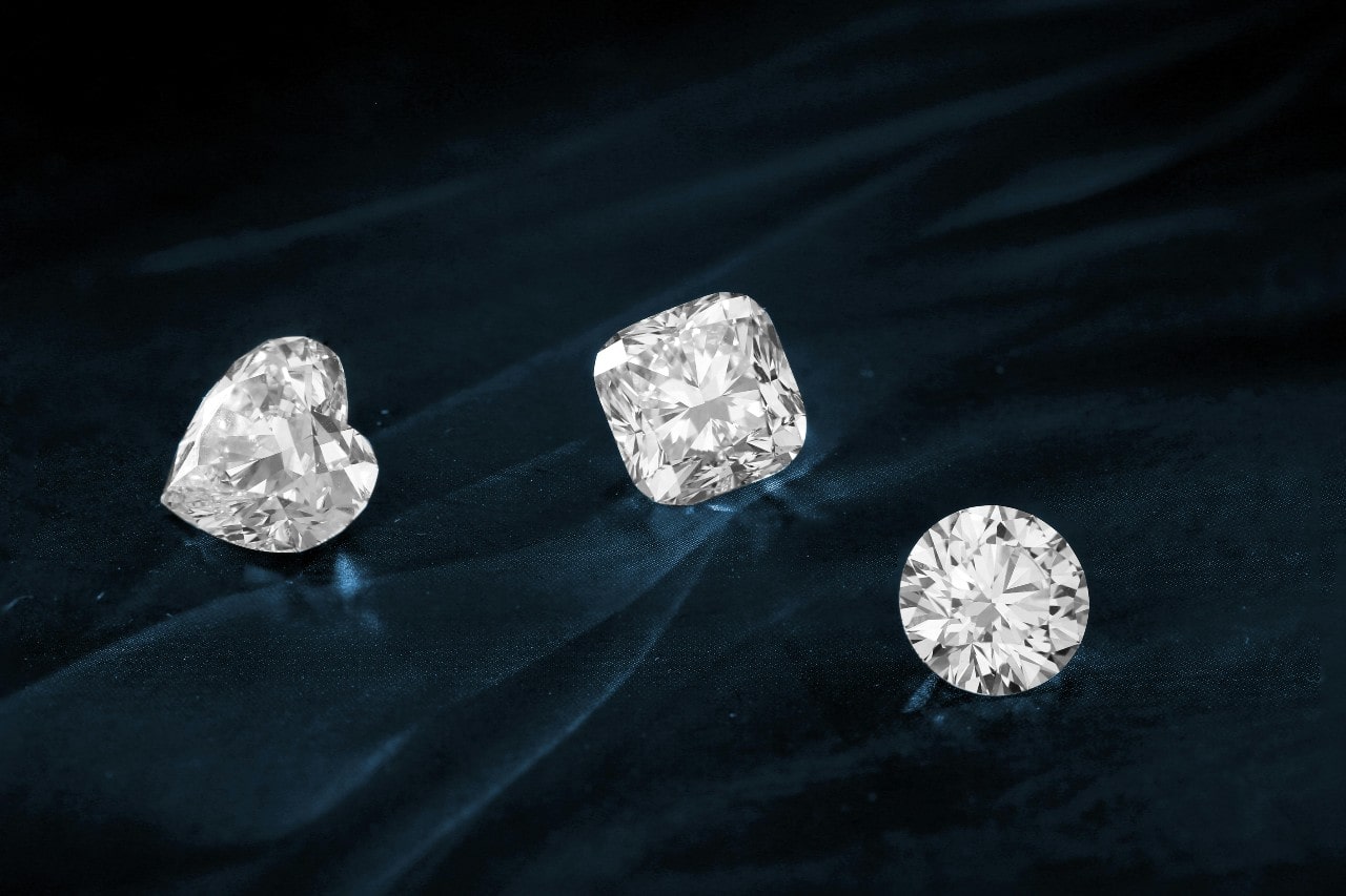 3 stunning diamonds on a dark blue velvet background.