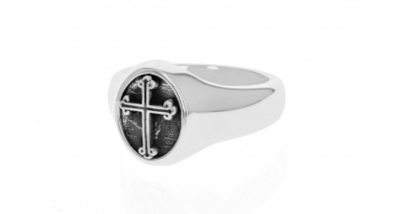 a silver toned ring with a cross motif against a black background