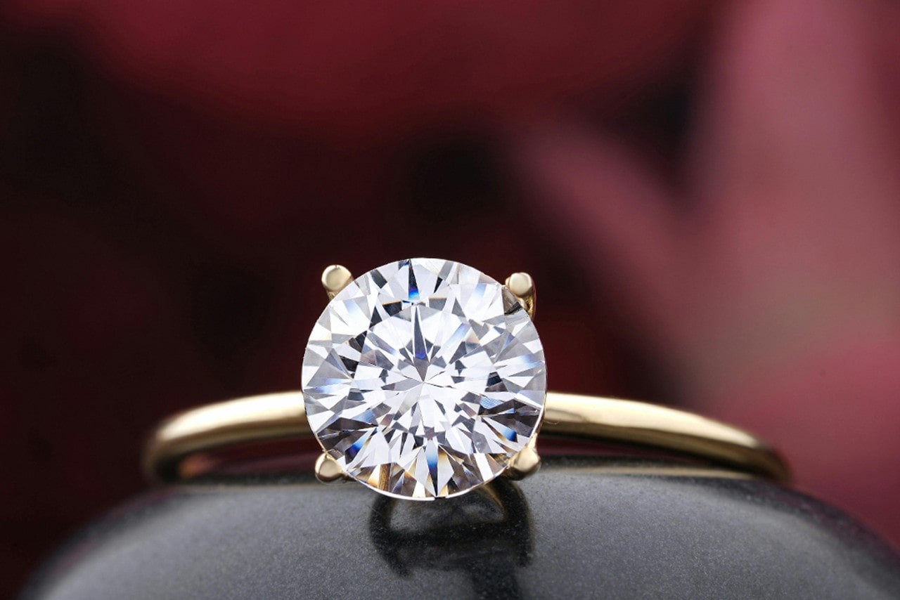A yellow gold solitaire engagement ring with round cut diamond.