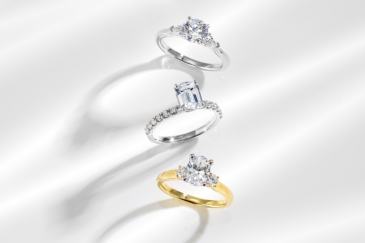 Two three stone engagement rings and a side stone ring all available from Huntington Fine Jewelers