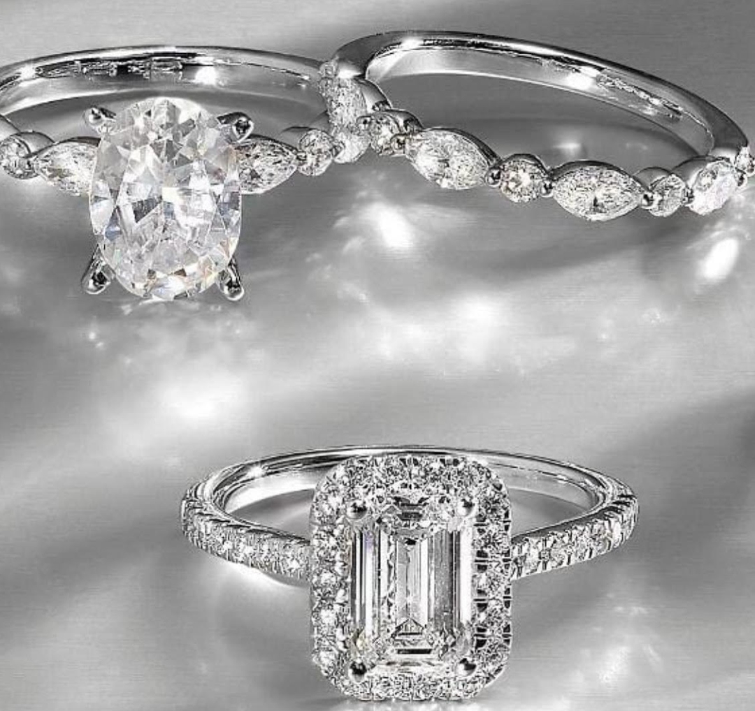 A close-up of a couple leaning in for a kiss, smiling warmly. A woman's hand, with a large diamond ring, gently touches the man's face.