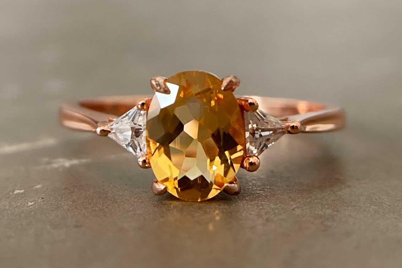 a rose gold fashion ring featuring an oval cut citrine and diamonds a rose gold fashion ring featuring an oval cut citrine and diamonds