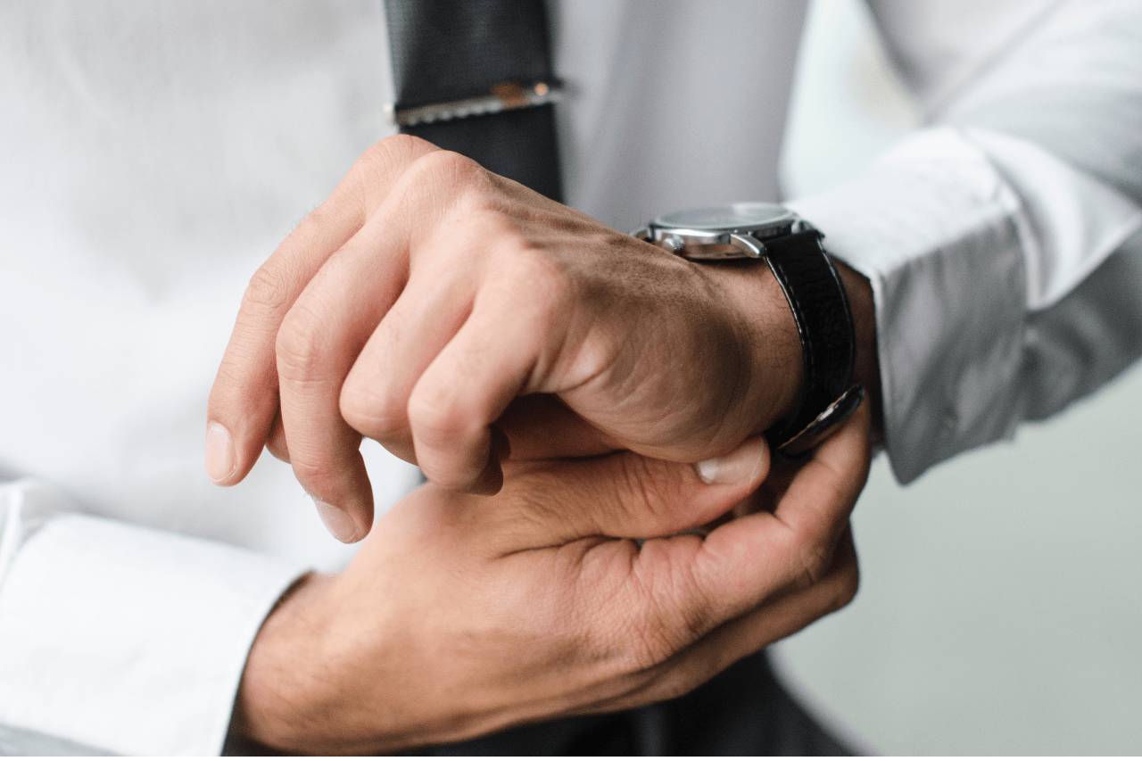 A businessman puts on his watch while getting ready in the morning. A businessman puts on his watch while getting ready in the morning.