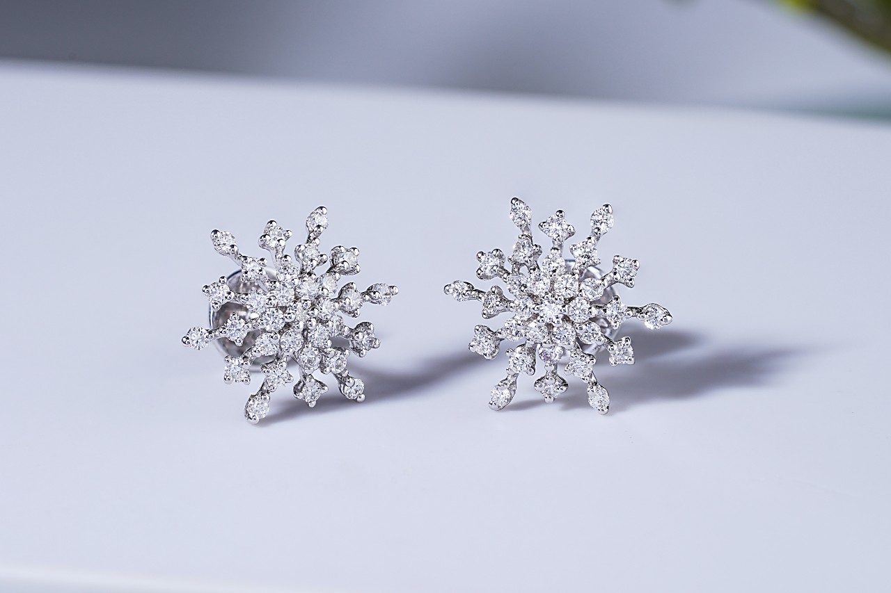 A diamond snowflake-shaped white gold studs on a white background