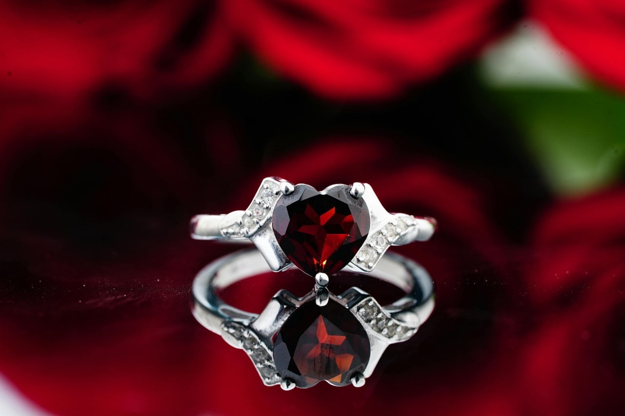 a white gold fashion ring featuring a heart cut ruby and diamond accents a white gold fashion ring featuring a heart cut ruby and diamond accents