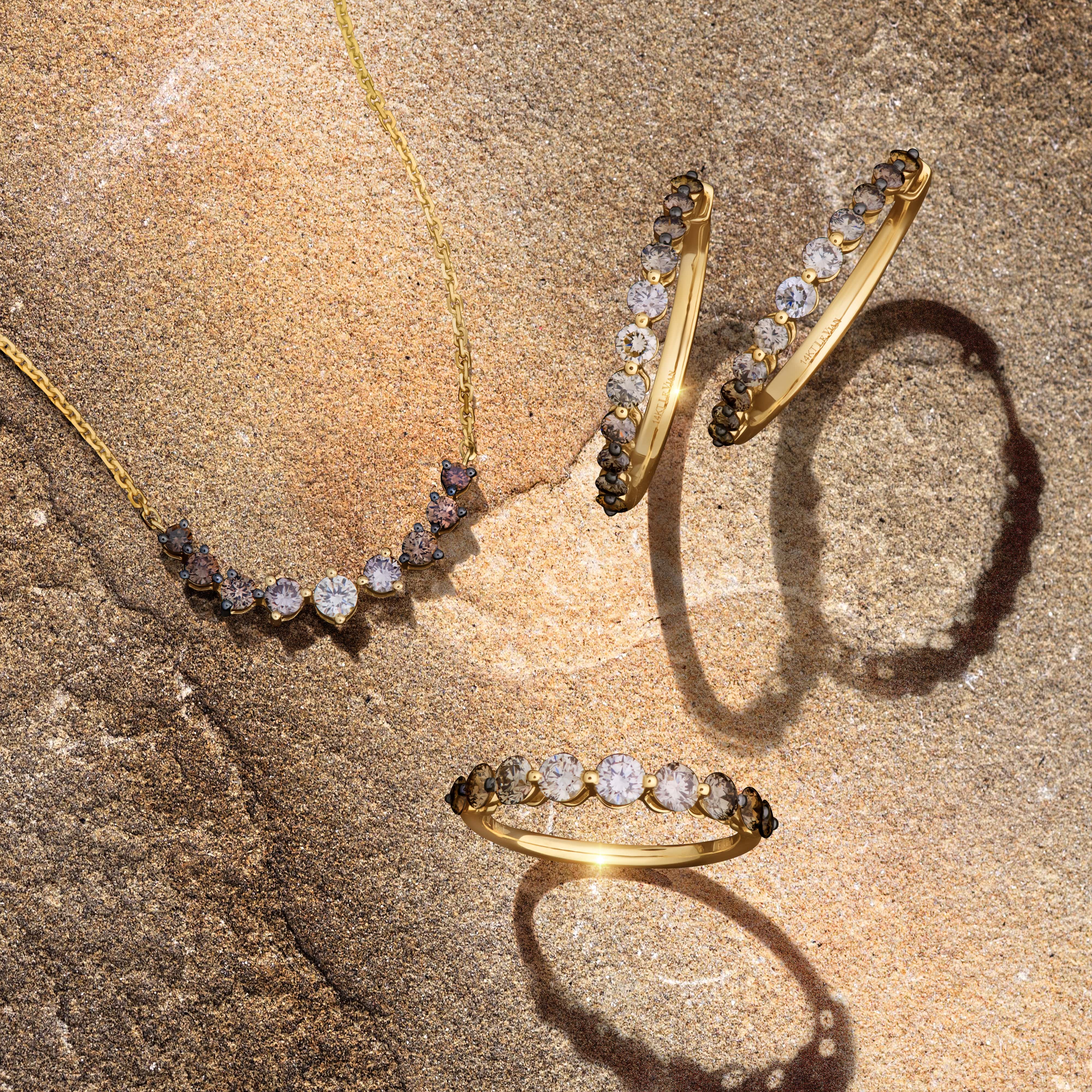 A close-up of a woman's hand, adorned with three delicate gold fashion rings.